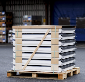 Several VELUX windows stacked on a pallet, ready for delivery using the pro-delivery service.