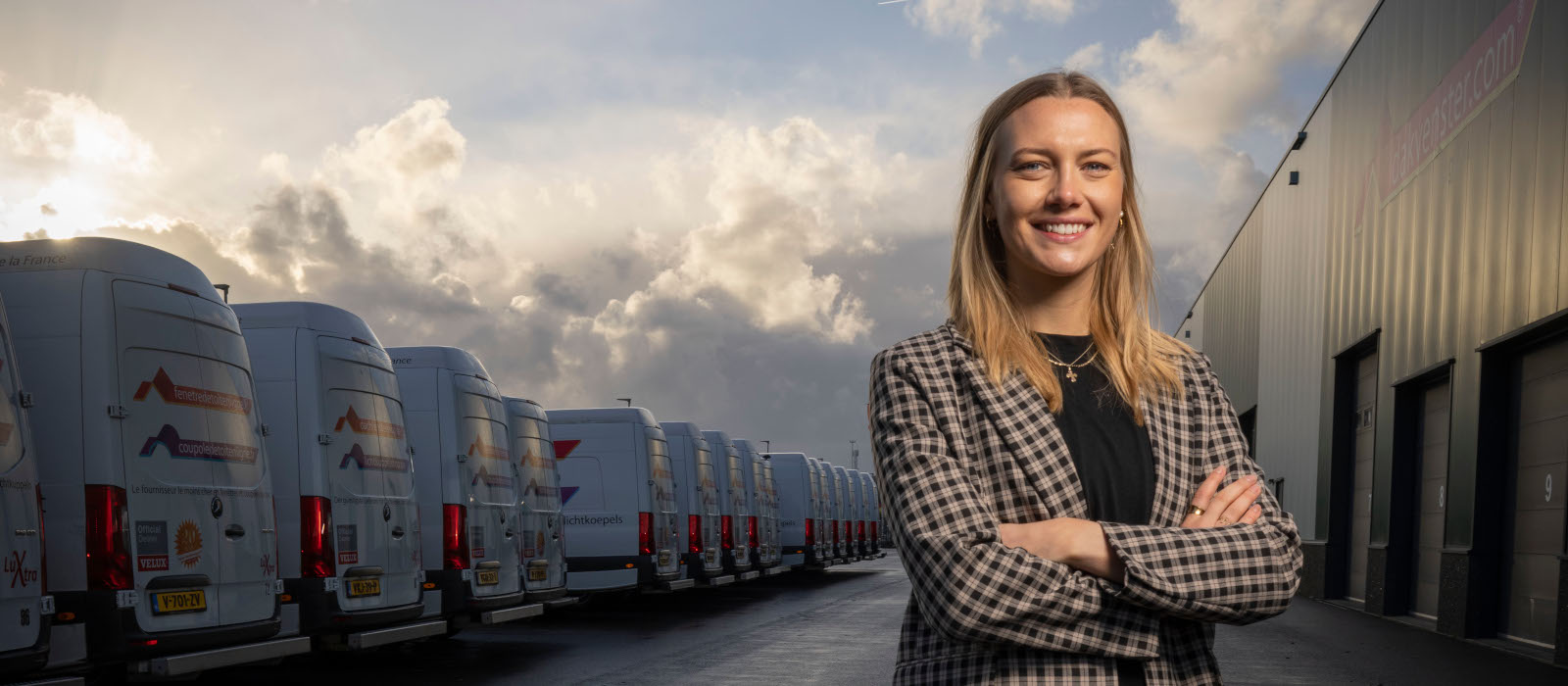 "Zakenvrouw die met gekruiste armen voor Dakvenster-busjes staat"